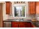 This kitchen sink features granite countertops and a window overlooking the yard, providing natural light at 11460 W Tanforan Cir, Littleton, CO 80127