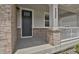 Close-up view of the front door with stylish brick accents and a covered porch at 7325 S Waterloo Way, Aurora, CO 80016
