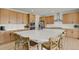 Modern kitchen with a large quartz island, light wood cabinets, stainless steel appliances, and eat-in breakfast bar at 7325 S Waterloo Way, Aurora, CO 80016