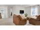 Inviting living room with leather seating, neutral carpet, and a mounted flat screen TV at 7325 S Waterloo Way, Aurora, CO 80016