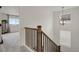 Bright staircase featuring a wooden railing, neutral carpet, and a modern spherical chandelier at 7325 S Waterloo Way, Aurora, CO 80016