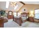 Vaulted ceiling bedroom with sky lights, a decorative bedframe, and wooden furniture at 170 Dover Ct, Castle Pines, CO 80108