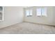 An airy carpeted room with two large windows allowing lots of natural light at 18712 E 99Th Ave, Commerce City, CO 80022