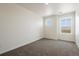 An airy carpeted room with two large windows allowing lots of natural light at 18712 E 99Th Ave, Commerce City, CO 80022