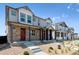 View of a row of townhomes featuring stone facades, covered porches, and well-maintained landscaping at 18712 E 99Th Ave, Commerce City, CO 80022