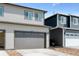 Two-story home with gray siding featuring a large two car garage at 18712 E 99Th Ave, Commerce City, CO 80022