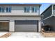 Two-story home with gray siding featuring a large two car garage at 18712 E 99Th Ave, Commerce City, CO 80022