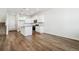 Bright kitchen with white cabinets, granite countertops, stainless steel appliances, and wood floors at 18712 E 99Th Ave, Commerce City, CO 80022