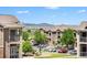 Apartment complex exterior with mountain views featuring balconies, a playground, and ample parking at 1425 Blue Sky Cir # 15-301, Erie, CO 80516