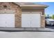 Attached garages with white doors and brick accents, showing convenient parking for residents at 1425 Blue Sky Cir # 15-301, Erie, CO 80516