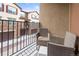A balcony with wicker chairs, a small stool, and views of the neighborhood at 2225 Santini Trl # C, Littleton, CO 80129