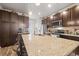 A kitchen with a large center island, stainless steel appliances, and dark brown cabinets at 2225 Santini Trl # C, Littleton, CO 80129