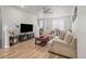 A staged living room with neutral furniture, decor, a ceiling fan, and wood flooring at 2225 Santini Trl # C, Littleton, CO 80129