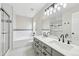 Bathroom with dual sinks, granite countertops, vanity, and tiled shower at 8773 S Dudley St, Littleton, CO 80128