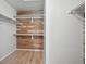 Walk-in closet with custom wood paneling, shelving and hardwood floors at 8773 S Dudley St, Littleton, CO 80128