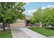 Charming exterior view of the home with mature trees, a long driveway, and a two-car garage at 8773 S Dudley St, Littleton, CO 80128