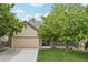 Charming home featuring a stone facade, well-maintained lawn, and a two-car garage at 8773 S Dudley St, Littleton, CO 80128