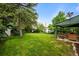 Expansive backyard with lush green lawn, mature trees, and patio area at 3231 S Elati St, Englewood, CO 80110