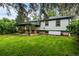 Large backyard showcasing the house, covered patio, and mature trees at 3231 S Elati St, Englewood, CO 80110