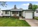 Inviting home featuring a well-kept lawn, dark green trim, and front bench, exuding classic charm at 3231 S Elati St, Englewood, CO 80110