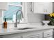 Close up on a kitchen sink. White cabinets, stone counter, and stainless steel faucet highlight the space at 3231 S Elati St, Englewood, CO 80110