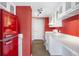 Retro kitchen featuring vibrant red walls, white cabinetry, and modern appliances at 1250 N Humboldt St # 202, Denver, CO 80218