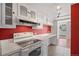 Functional kitchen with white cabinets, range hood, and a view of the balcony at 1250 N Humboldt St # 202, Denver, CO 80218