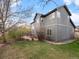 Back of home and backyard featuring a red-stained concrete patio and grassy yard at 11910 W 83Rd Pl, Arvada, CO 80005