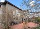 Back of home and backyard featuring a red-stained concrete patio, mature trees, and landscaping at 11910 W 83Rd Pl, Arvada, CO 80005
