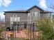 Back of home featuring a red-stained concrete patio with black iron gazebo and manicured landscaping at 11910 W 83Rd Pl, Arvada, CO 80005