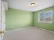 This bedroom features neutral carpet, ample light, and a soothing green tone at 11910 W 83Rd Pl, Arvada, CO 80005