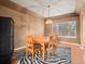 Dining room with wood table set, large window, zebra-print rug and black accent cabinet at 11910 W 83Rd Pl, Arvada, CO 80005
