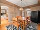 Inviting dining room features wooden table and chairs, striking zebra-print rug, and decorative lighting fixture at 11910 W 83Rd Pl, Arvada, CO 80005