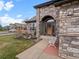 Inviting entryway featuring stone detailing, a decorative bench, and a stylish front door at 11910 W 83Rd Pl, Arvada, CO 80005