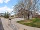 Landscaped front yard with mature trees and a spacious driveway leading to a two-car garage at 11910 W 83Rd Pl, Arvada, CO 80005