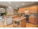Open kitchen design with stainless appliances, island, and breakfast bar at 11910 W 83Rd Pl, Arvada, CO 80005