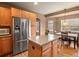 Well-lit kitchen featuring stainless steel appliances, center island, and adjacent dining area at 11910 W 83Rd Pl, Arvada, CO 80005