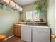 Functional laundry room equipped with a sink, countertop space, and a window for natural light at 11910 W 83Rd Pl, Arvada, CO 80005