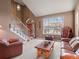 Bright living room features a high ceiling, staircase and large window at 11910 W 83Rd Pl, Arvada, CO 80005