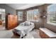 Cozy bedroom sitting area with natural light, a comfortable chair, and built-in shelving at 11910 W 83Rd Pl, Arvada, CO 80005