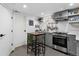 This kitchen offers stainless steel appliances, gray cabinets, and a kitchen island with seating at 3730 Lowell Blvd, Denver, CO 80211