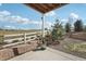 View of the covered back patio with privacy fence, landscaping, and sunny sky at 2188 Abigail Ln, Castle Rock, CO 80104