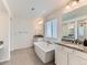 Bright bathroom features a soaking tub, dual sinks, granite countertops, and modern fixtures at 11657 Olathe St, Commerce City, CO 80022