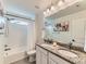Bright bathroom featuring a double vanity, granite countertop, and shower-tub combo at 11657 Olathe St, Commerce City, CO 80022