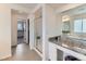 Bright bathroom featuring a glass shower, dual sinks, granite countertops, and a walk in closet at 11657 Olathe St, Commerce City, CO 80022