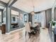 Modern dining room featuring an elegant chandelier, a large mirror, and hardwood floors at 11657 Olathe St, Commerce City, CO 80022