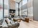 Grand living room featuring a stone fireplace, high ceilings, and modern furnishings at 11657 Olathe St, Commerce City, CO 80022