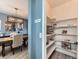 Organized walk-in pantry with shelves, adjacent to a dining room with modern lighting at 11657 Olathe St, Commerce City, CO 80022