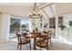 Sunlit dining room boasts vaulted ceilings, chandelier, and deck access with beautiful treed views at 12493 Forest Canyon Dr, Parker, CO 80138