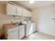 Functional laundry room with updated appliances and ample storage cabinets above at 12493 Forest Canyon Dr, Parker, CO 80138